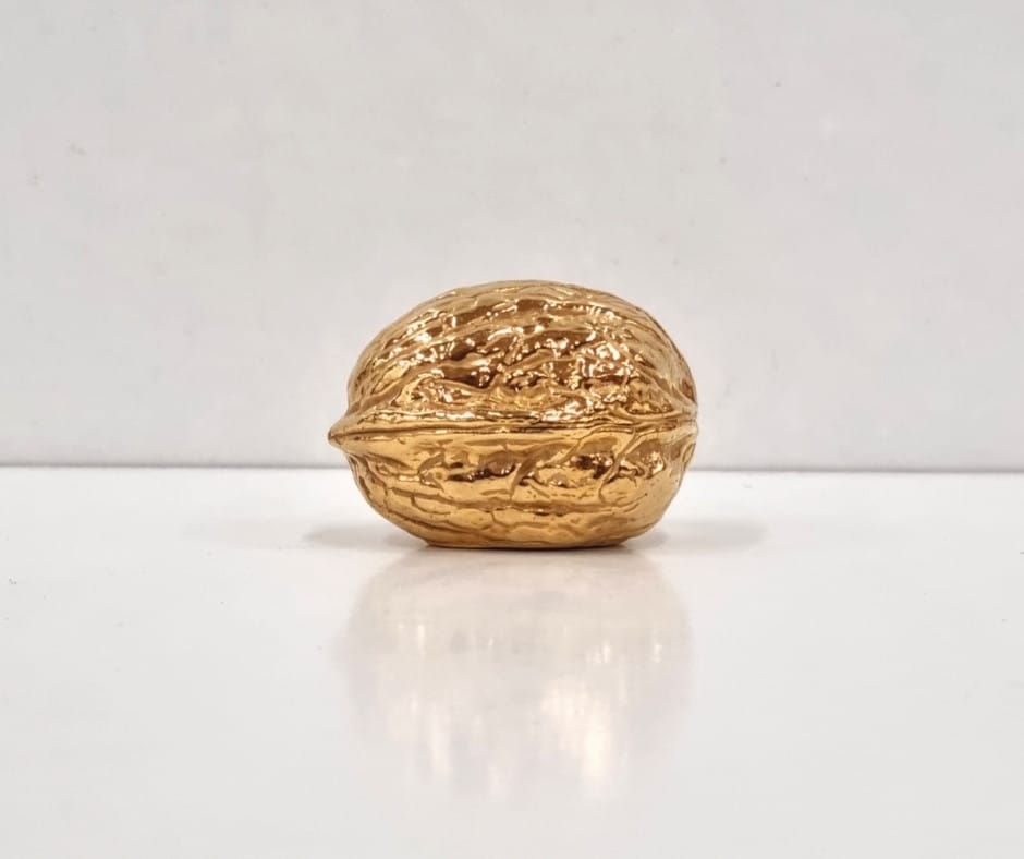Nuez maciza de plata bañada en oro de 18 quilates, símbolo de la marca Iuglandis