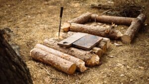 Troncos y tablas de madera recién cortada en el bosque, con un formón clavado en un tronco